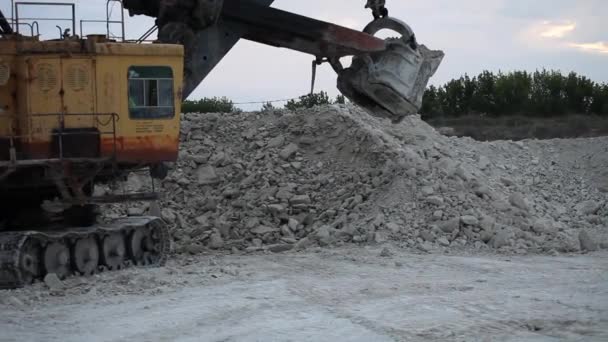 Pesado caminhão de descarga de mineração sendo carregado com minério de ferro no poço — Vídeo de Stock