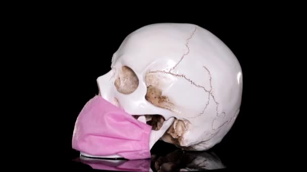 暗い背景の医療マスクの人間の頭蓋骨 致命的なコロナウイルス流行の概念 Covid — ストック動画