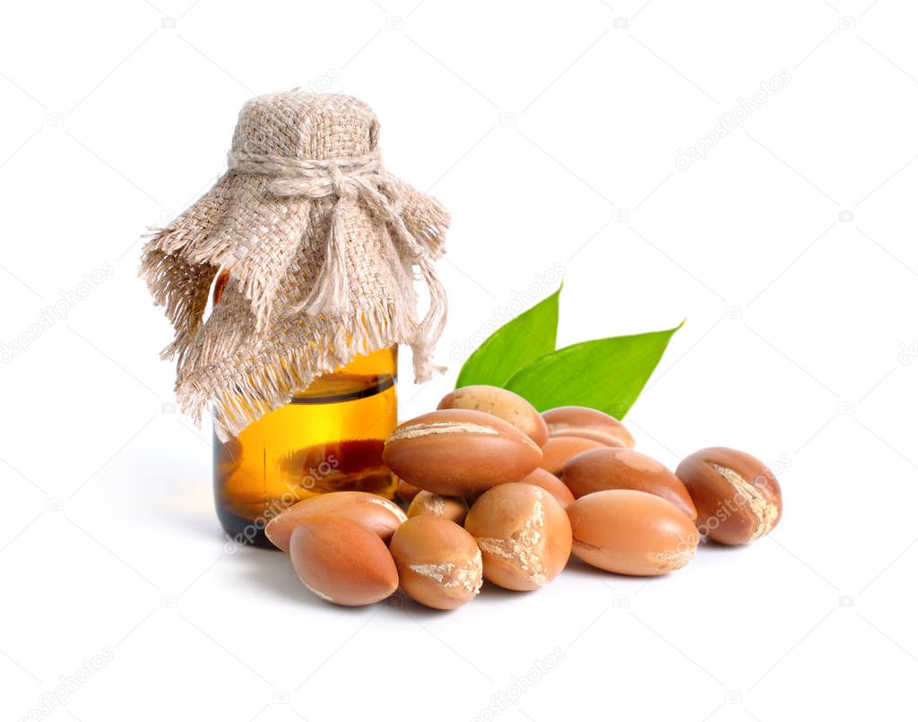 Argan seed  with pharmaceutical bottle. Isolated  on white backg