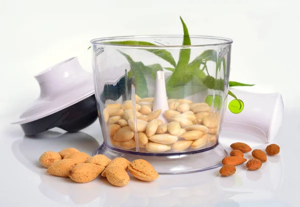 Blancherade mandlar i en mixer med oskalade nötter. På vit baksida — Stockfoto
