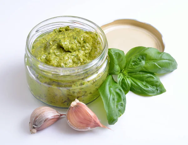 Molho de pesto em um jarro de vidro com manjericão e alho . — Fotografia de Stock