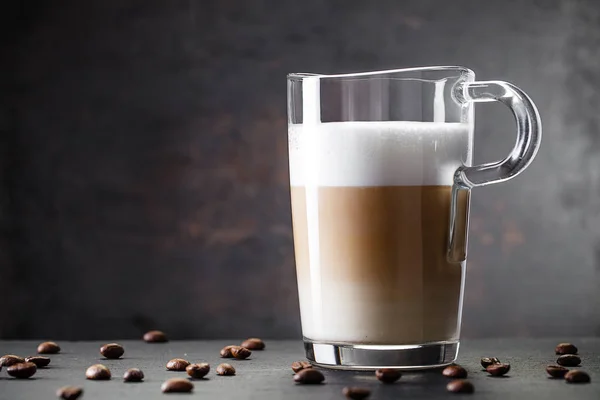 Sklenice latte a kávová zrna — Stock fotografie
