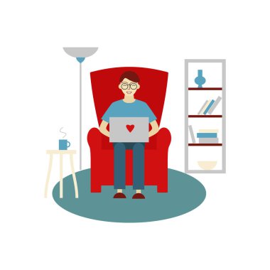 Evde çalışan bir adam. Genç bir adam elinde dizüstü bilgisayarla bir sandalyede oturuyor. Evde çalış..