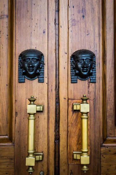 Entrada de cabezas de esfinge en puerta de madera —  Fotos de Stock