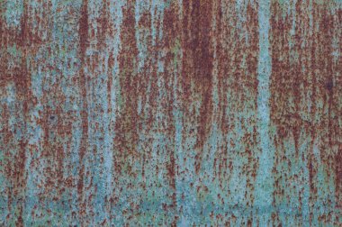 Paslı mavi boyanmış metal duvar.