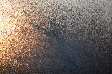 Ağaçlar siluet ile gün batımında camına yağmur damlaları.