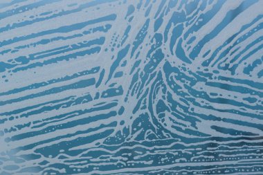 Sabun köpük desen ve kabarcıklar camına. Mavi arka plan.