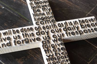 Beyaz ahşap çarmıhta buluşmalarımıza dua ile eski püskü koyu ahşap tahta.