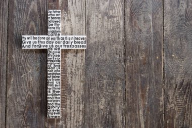 Beyaz ahşap çarmıhta buluşmalarımıza dua ile eski püskü koyu kahverengi ahşap tahta.