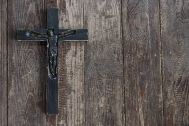 Eski püskü koyu kahverengi ahşap tahta üzerinde siyah tahta haç.