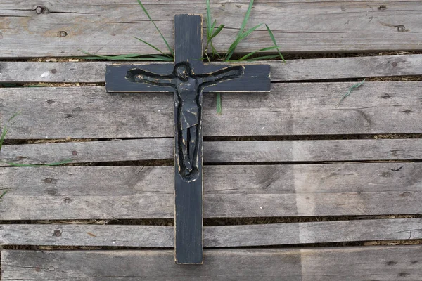 Yıpranmış ahşap tahta arka plan üzerinde siyah tahta haç.