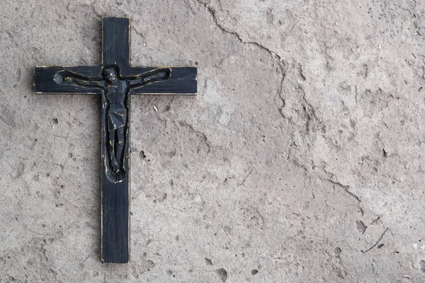 Arka plan siyah tahta haç ile gri beton üzerinde çatlaklar.