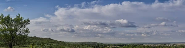 Vista panoramica. Paesaggio di una valle pittoresca e alberi verdi con piccolo villaggio sullo sfondo del cielo blu . — Foto Stock