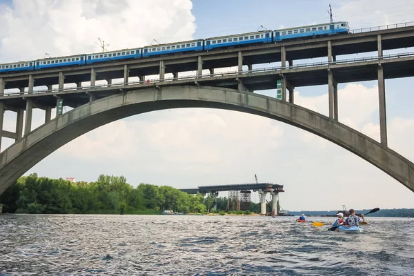 Поїзд їде через міст через річку на блакитне небо — стокове фото