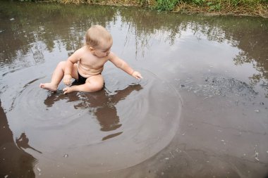 Çocuk büyük kirli çamura oynuyor. Mutlu çocukluk