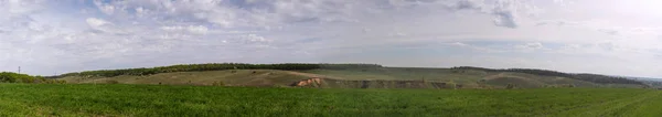 Vista panorámica. Hermoso paisaje natural. Colinas verdes, prados y bosques sobre un fondo azul del cielo — Foto de Stock