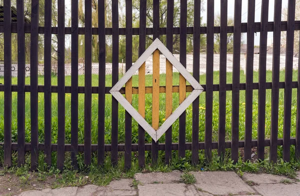 Ancienne clôture en bois avec un losange jaune au centre — Photo