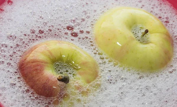 red green Apple one lies in soapy water, the concept of purity of fruit