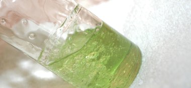 Çalkalanmış şeffaf bir şişede yeşil sıvı