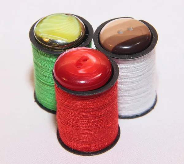 三卷红线 绿线和白线 顶部有纽扣 在白色背景上缝制配件 — 图库照片