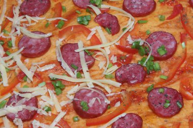 Bitmiş pizzanın dokusu erimiş peynir ve füme sosis ile üst katmanın dokusudur. Mutfak tabağı pişirme süreci.
