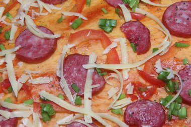 Bitmiş pizzanın dokusu erimiş peynir ve füme sosis ile üst katmanın dokusudur. Mutfak tabağı pişirme süreci.