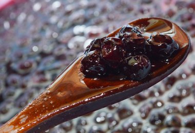 Tahta kaşıkta kiraz. Reçel yapma süreci. Taze böğürtlen kışı için tatlı hasat..