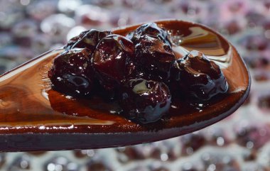 Tahta kaşıkta kiraz. Reçel yapma süreci. Taze böğürtlen kışı için tatlı hasat..