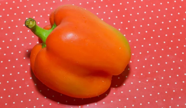 sweet red bell pepper on a red background with polka dots