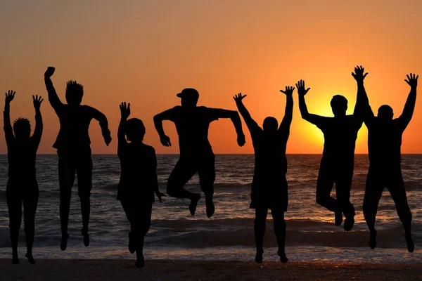 Grupo de siluetas de personas saltando — Foto de Stock