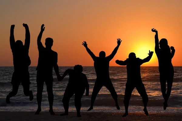 Silhouetten van mensen springen — Stockfoto