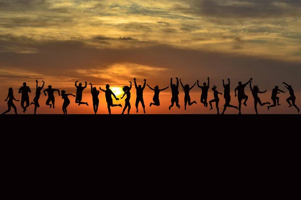 Щасливі чоловіки і жінки стрибають на сході сонця — стокове фото