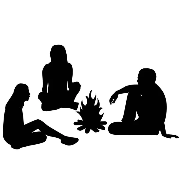 Silhouettes of tourists sitting around a campfire — Stock Vector