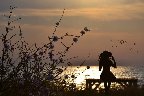 Nostalgic woman siting on a bench by the sea — Stock Photo, Image