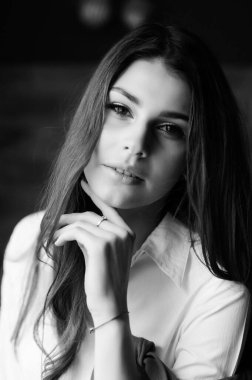 Beyaz gömlekli güzel esmer bir kızın portresi.