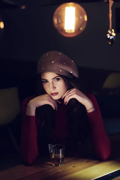 Πορτρέτο Ενός Όμορφου Μελαχρινού Κοριτσιού Ένα Κόκκινο Πουλόβερ Στο Τραπέζι — Φωτογραφία Αρχείου