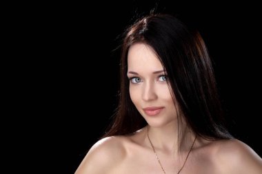 Siyah arka planda poz veren güzel, seksi esmer kız.