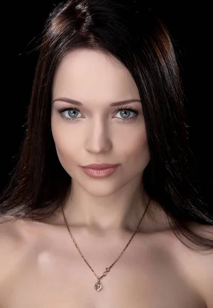 Siyah arka planda poz veren güzel, seksi esmer kız.