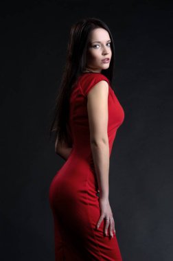 Siyah arka planda poz veren güzel, seksi esmer kız.