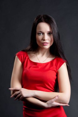 Siyah arka planda poz veren güzel, seksi esmer kız.