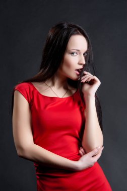 Siyah arka planda poz veren güzel, seksi esmer kız.