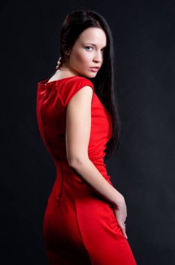 Siyah arka planda poz veren güzel, seksi esmer kız.