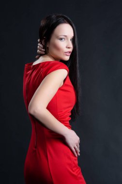 Siyah arka planda poz veren güzel, seksi esmer kız.