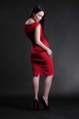 Siyah arka planda poz veren güzel, seksi esmer kız.