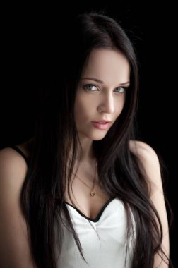 Siyah arka planda poz veren güzel, seksi esmer kız.