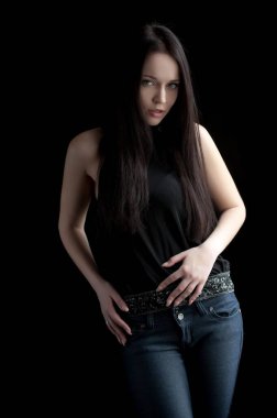 Siyah arka planda poz veren güzel, seksi esmer kız.