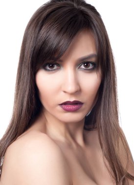 Güzel, seksi esmer kız beyaz bir arka planda poz veriyor.