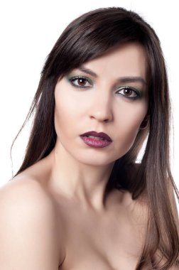 Güzel, seksi esmer kız beyaz bir arka planda poz veriyor.