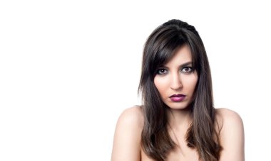 Güzel, seksi esmer kız beyaz bir arka planda poz veriyor.