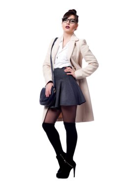 Güzel, seksi esmer kız beyaz bir arka planda poz veriyor.